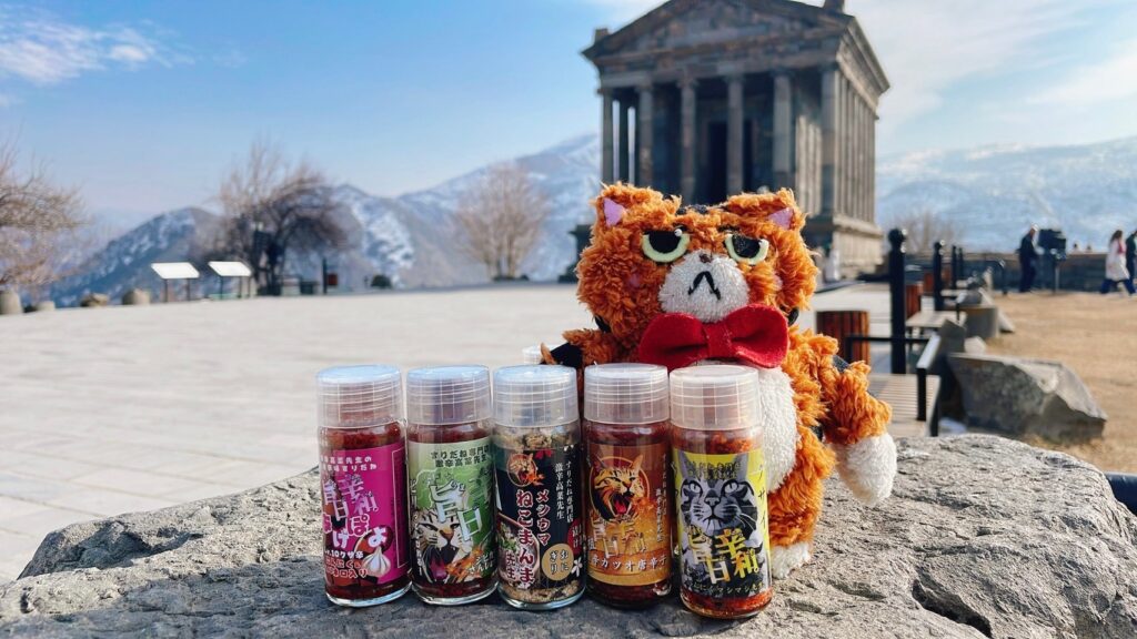 海外の遺跡前で激辛高菜先生のスパイスと猫のぬいぐるみを撮影
